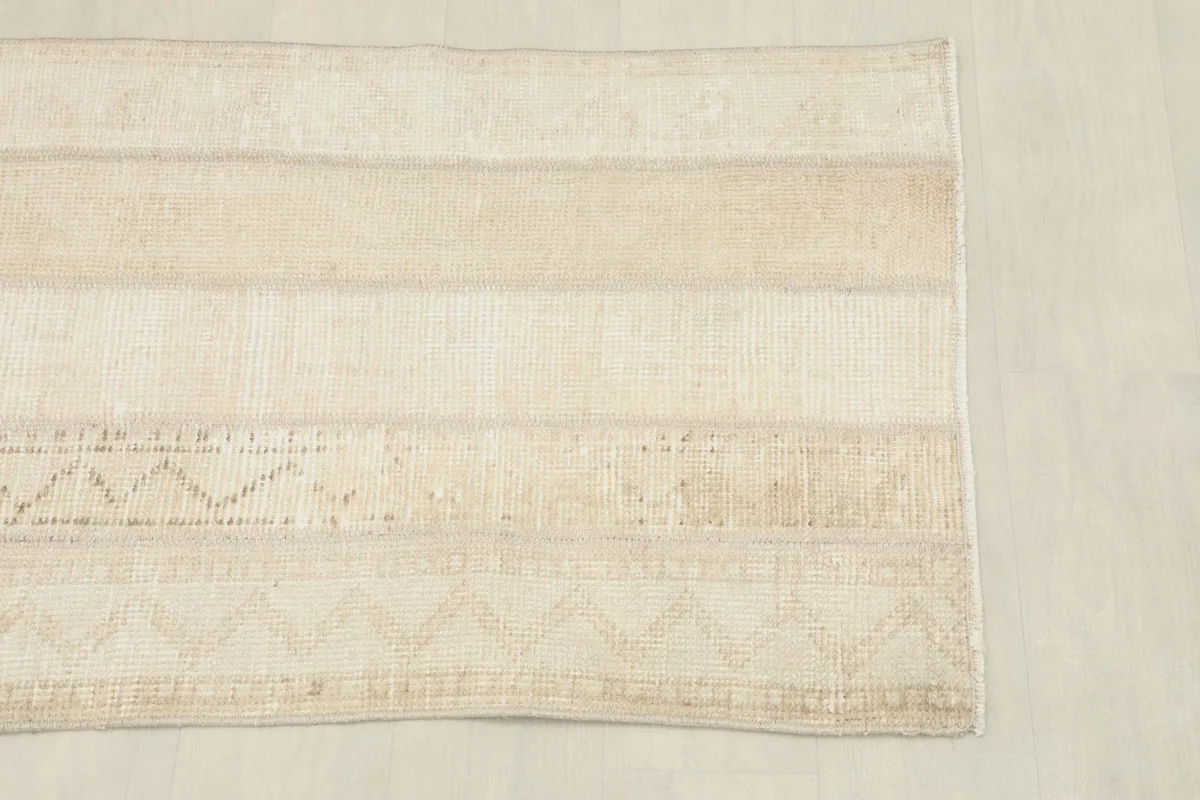 Overhead view of a section of the rug, showing the blend of light beige and cream tones.