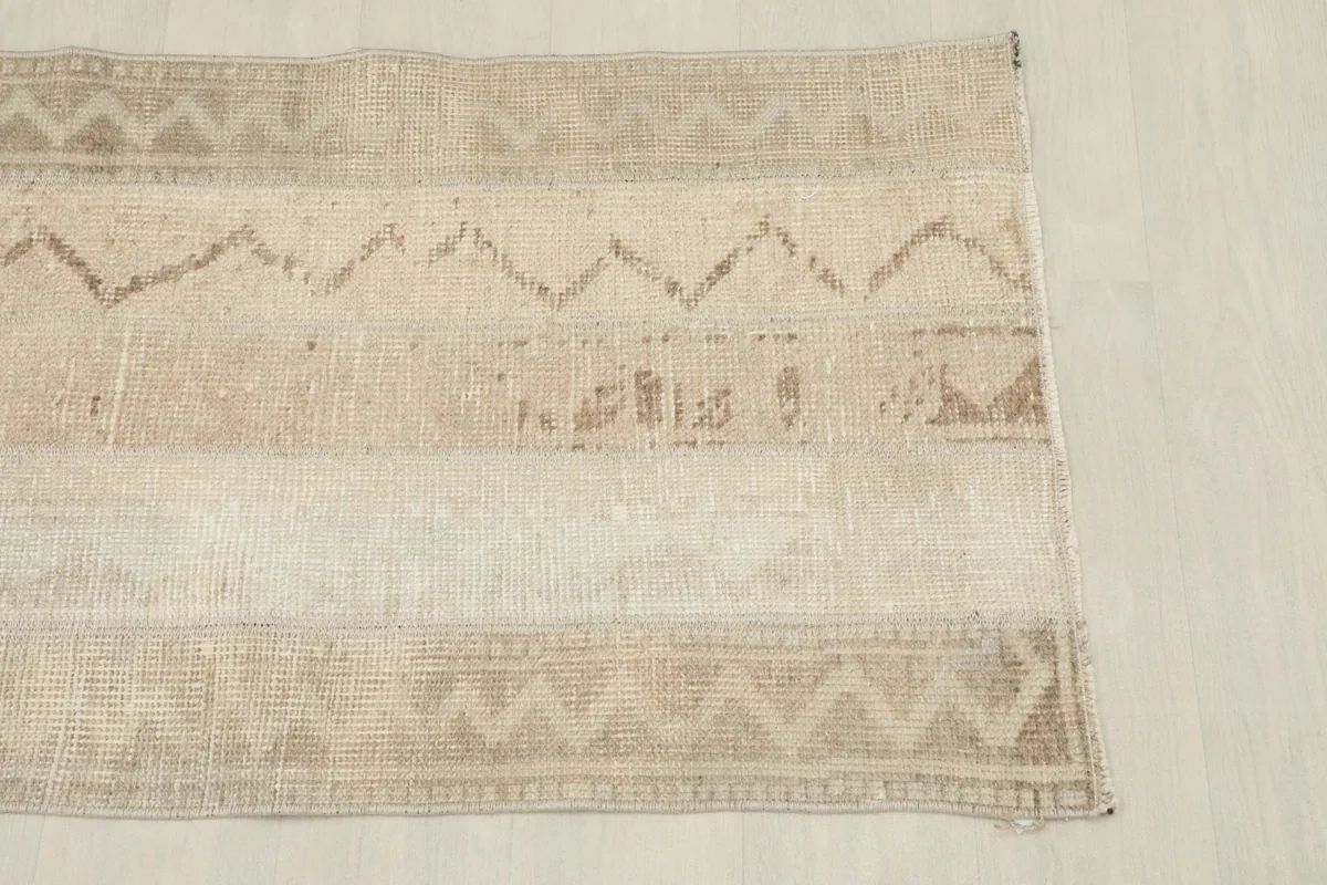 Close overhead view of the top section of the beige runner, showing geometric patterns