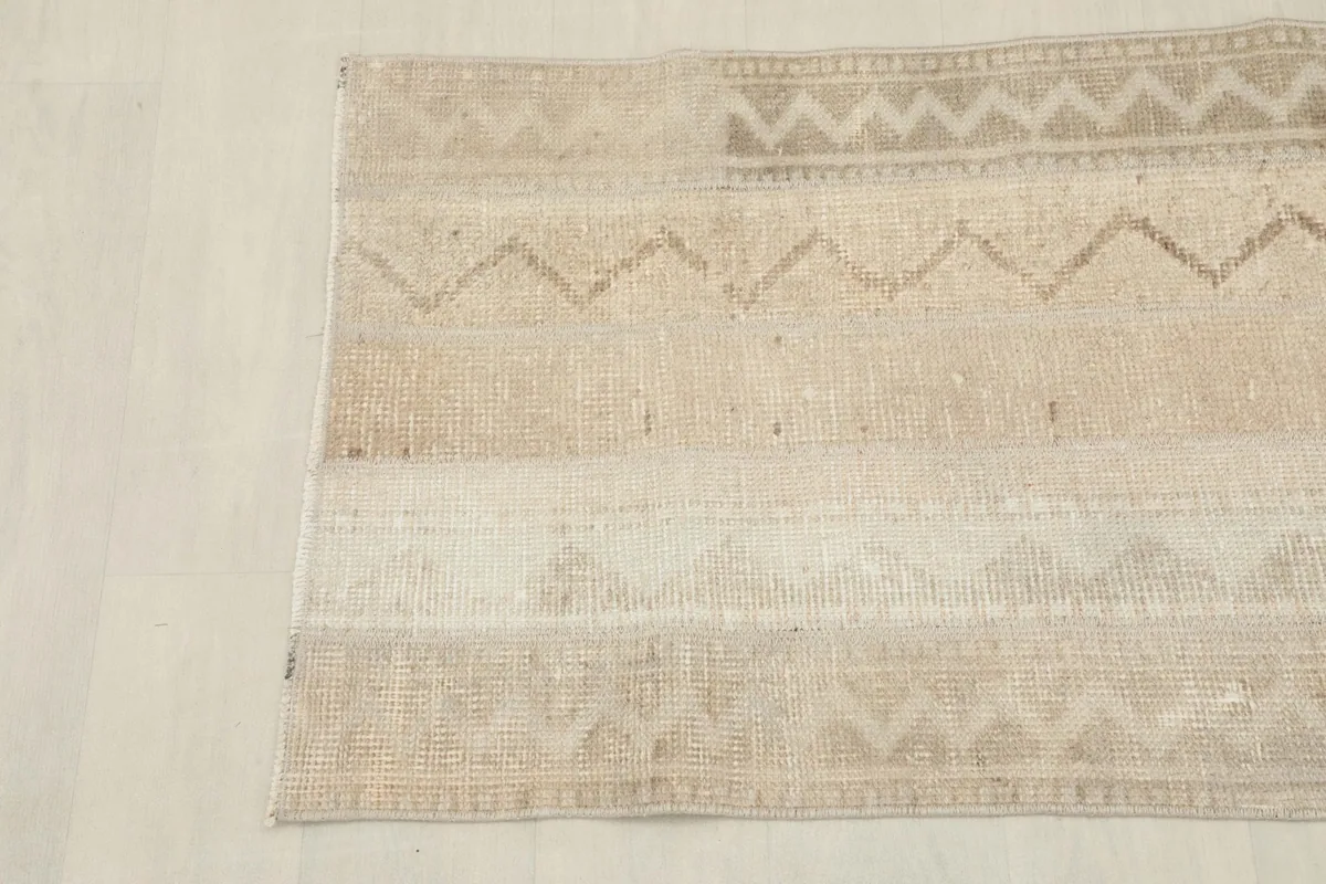 Close overhead view of the bottom section of the beige runner, highlighting tonal variations