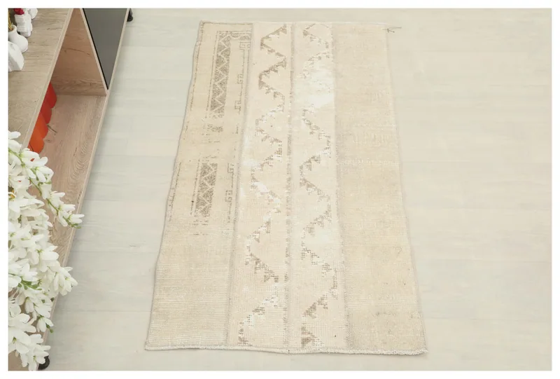 Full top view of the beige and tan geometric striped vintage Anatolian rug on a white floor