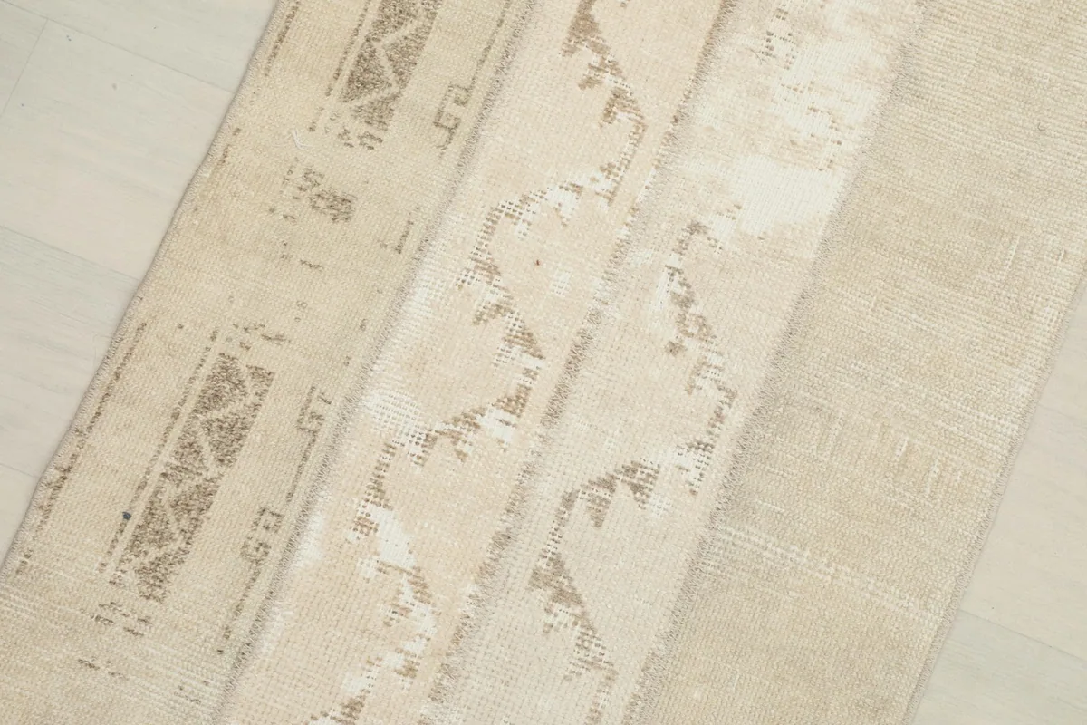 Close-up detail of the central geometric striped pattern and varied beige tones
