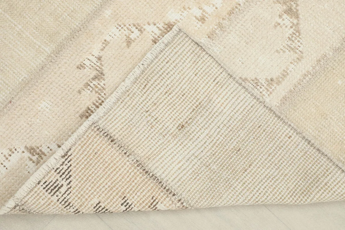 View of the underside of the rug, revealing the cotton foundation and hand-knotting
