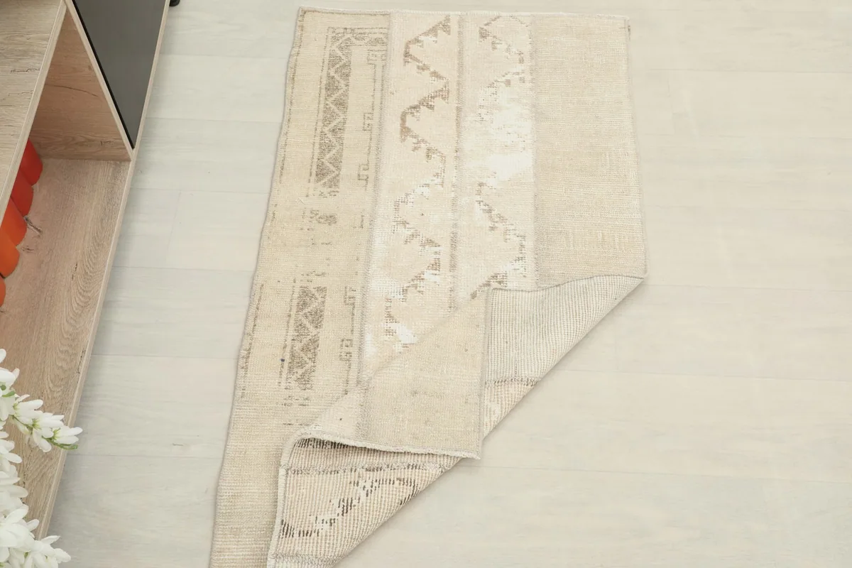 The rug partially folded, showing the thickness and flexibility of the vintage wool material