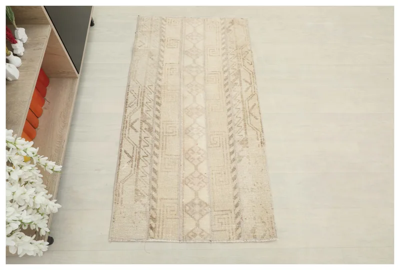 Full top view of the beige and brown geometric Anatolian rug on a white floor