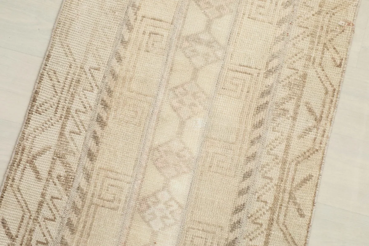 Close-up detail of the beige and brown geometric patterns and texture of the rug pile