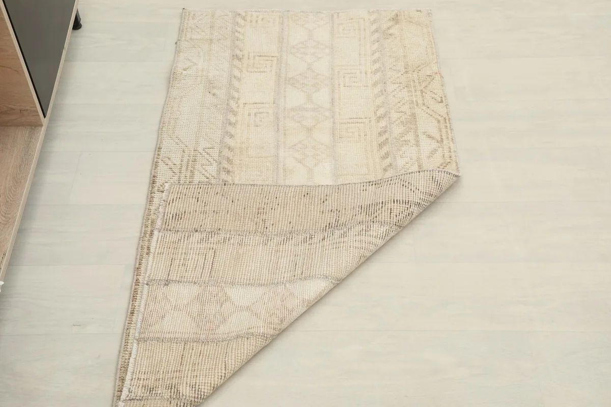Rug partially folded, showing the flexibility and thickness of the vintage wool pile