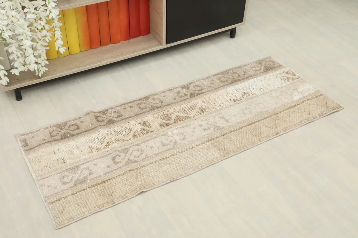 Angled view of the beige and tan runner rug showcasing its geometric patterns in a room setting.