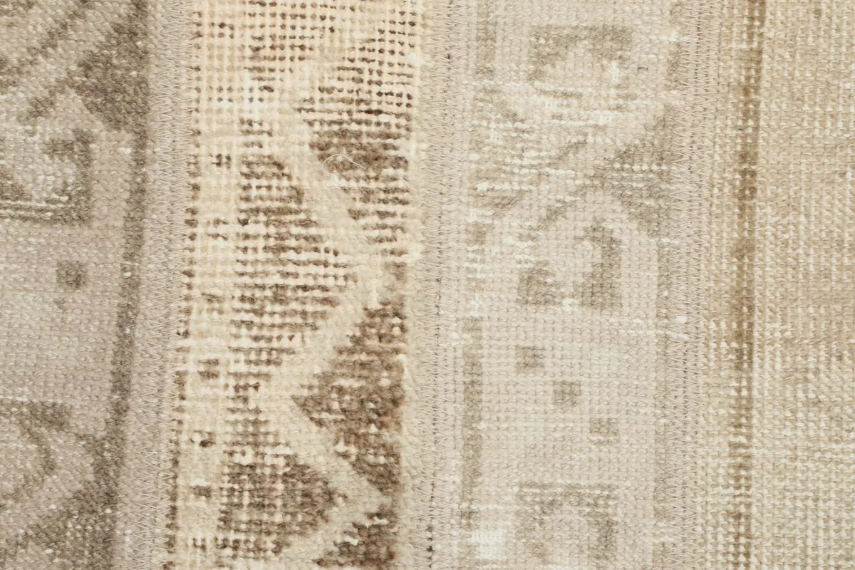 Detailed close-up of the distressed pile and intricate hand-knotted geometric patterns.