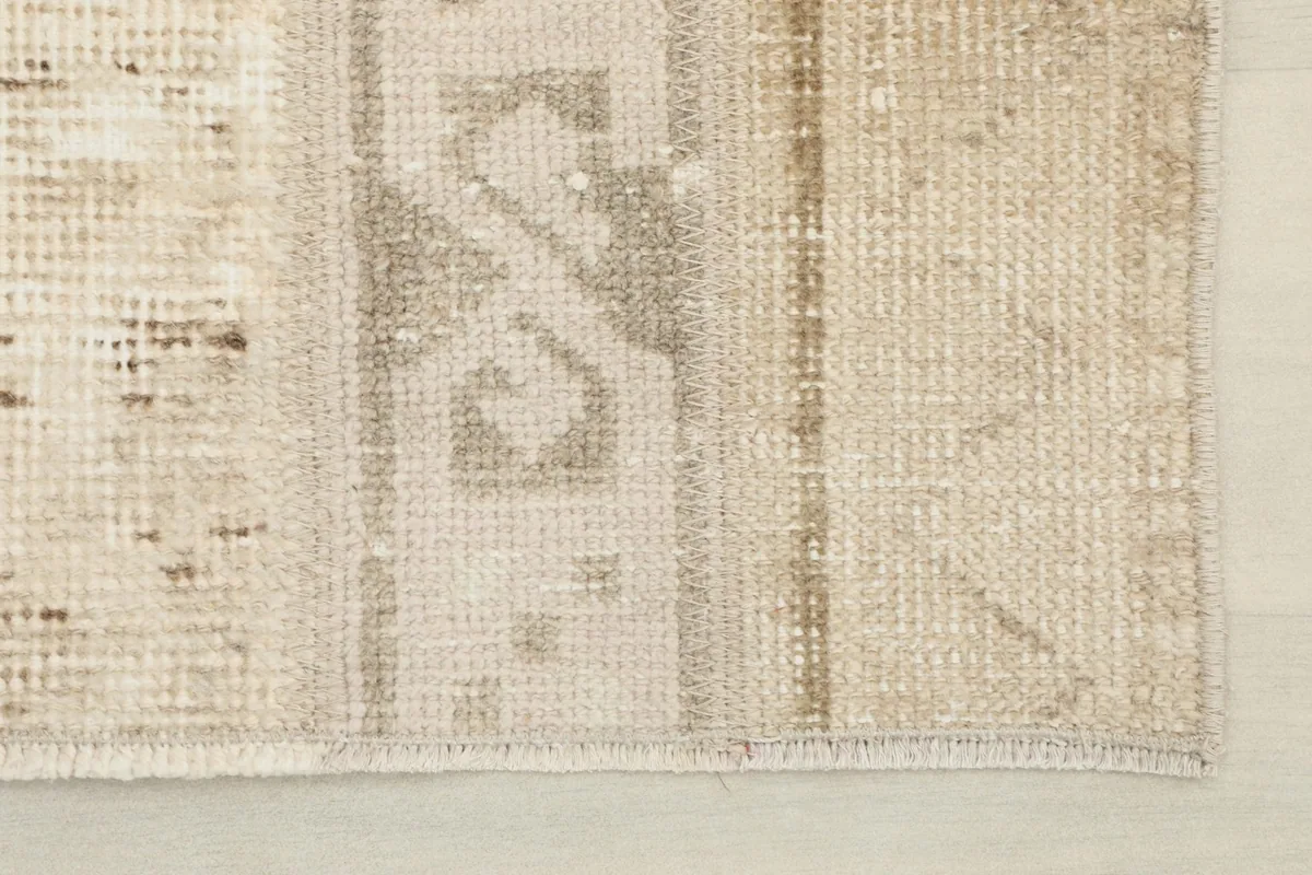 Close-up view of the rug's edge, showing the subtle fringe and weave texture.