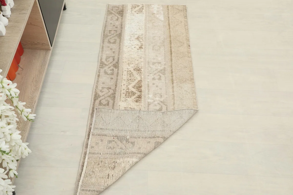 Angled view of the runner rug with a corner folded over, revealing the underside texture.