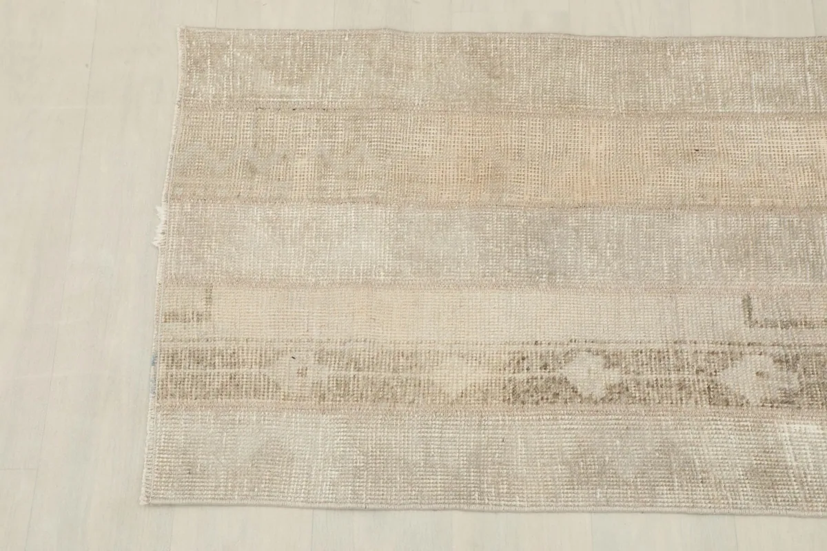 Detailed view of the rug's top left corner, revealing subtle color variations and wear