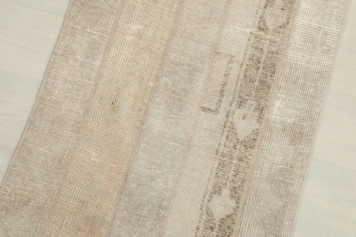 Close-up showing the distinct patchwork seams and areas of low pile on the rug