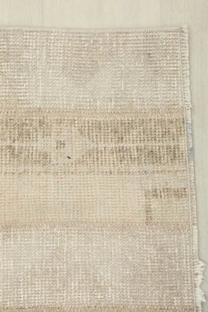 Corner detail of the rug, illustrating the hand-knotted wool pile and cotton foundation