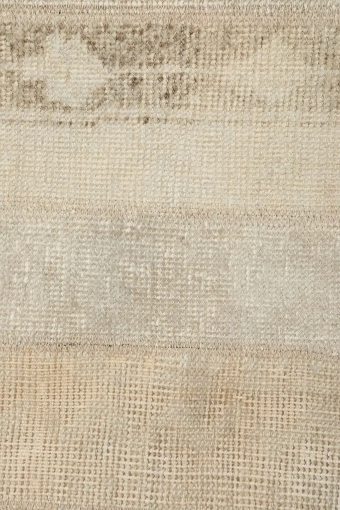 Extreme close-up of the rug's low wool pile and intricate weave
