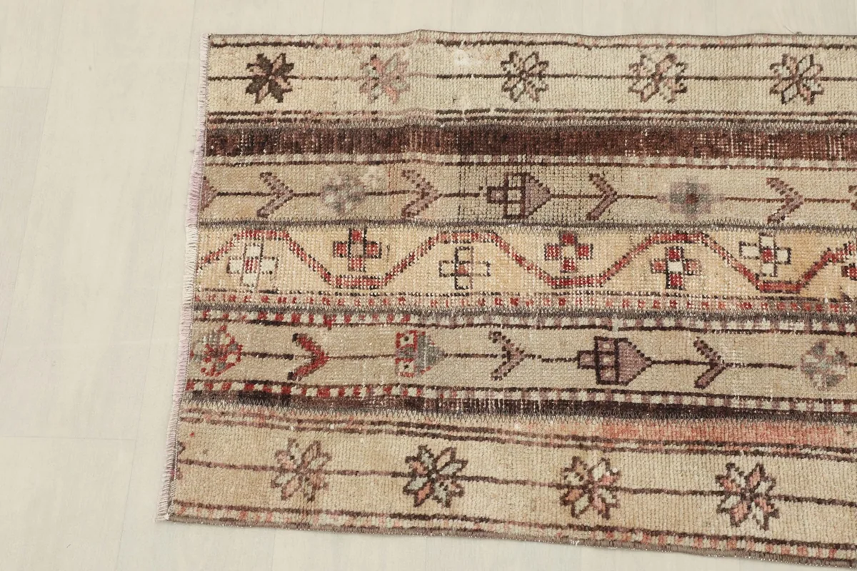 Detailed view of the rug's border and central striped patterns with geometric shapes.