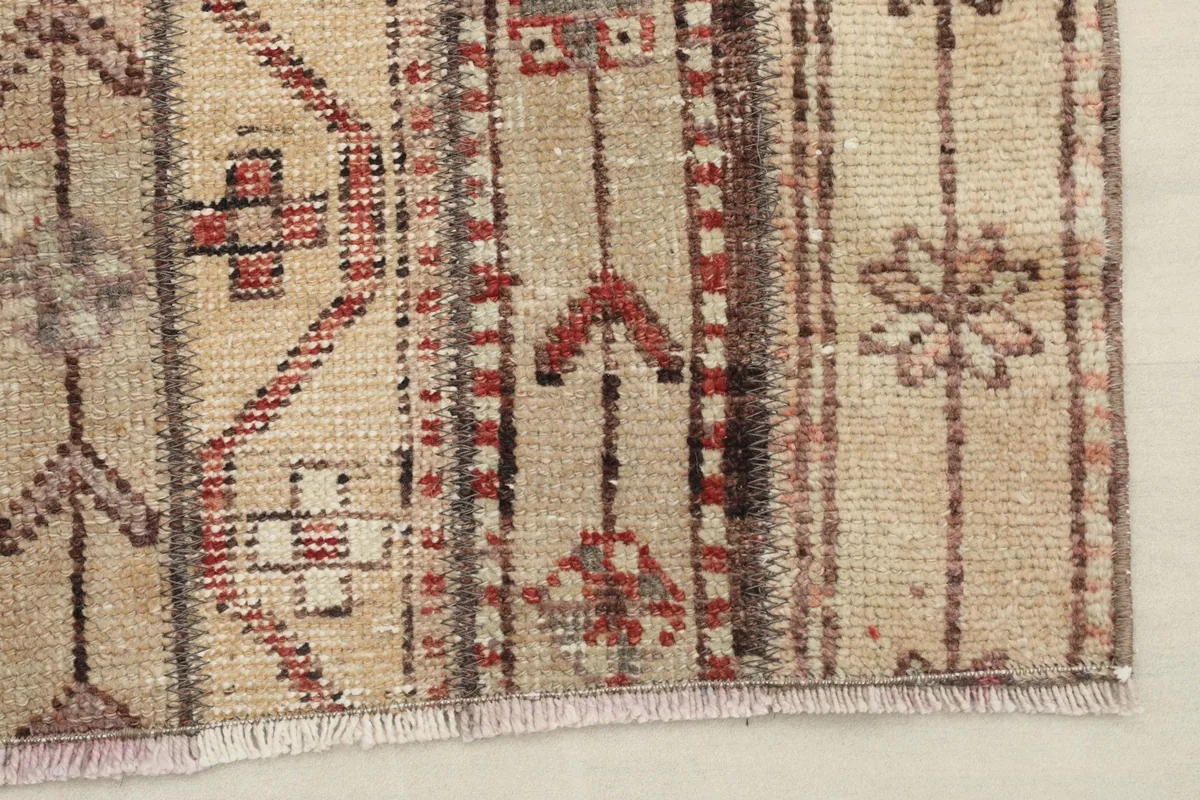 Close-up of the rug's edge, showing the hand-knotted wool pile and cotton foundation.
