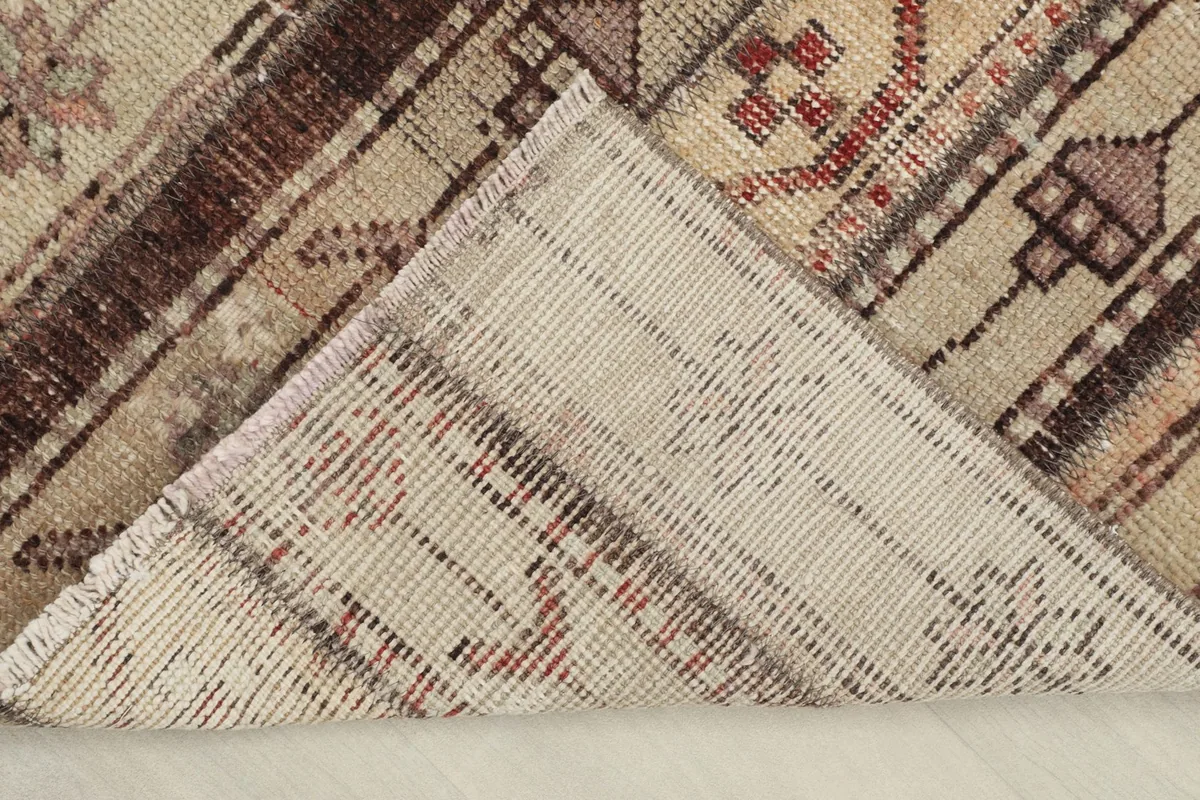 View of the rug's backside, showing the tight hand-knotted construction and cotton foundation.
