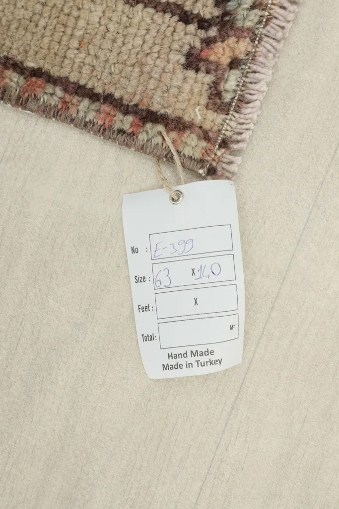 Close-up of the rug's tag, indicating hand-made in Turkey and the rug's dimensions.