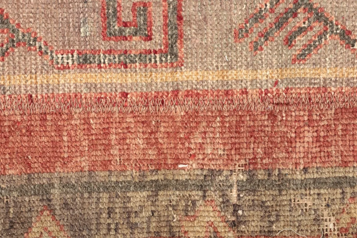 Extreme close-up of the low wool pile, showing individual knots and color variations.