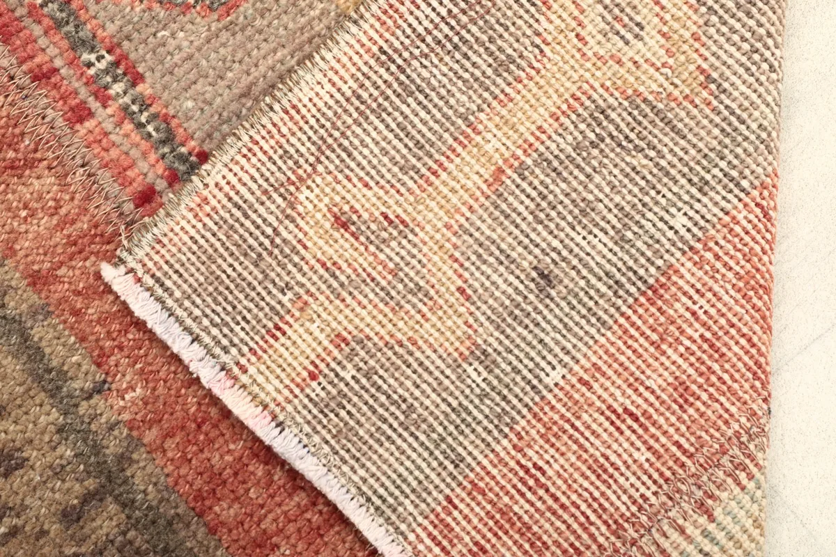 View of the back of the rug, showing the hand-knotted construction and cotton foundation.