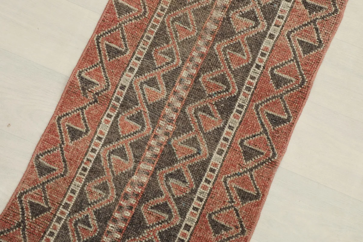 Close-up detail of the rust and charcoal geometric patterns in the rug's center