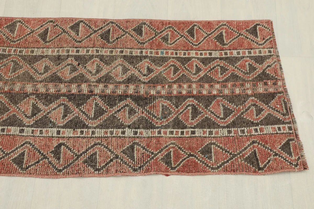 Detailed view of the repeating tribal geometric motifs and border on the vintage runner