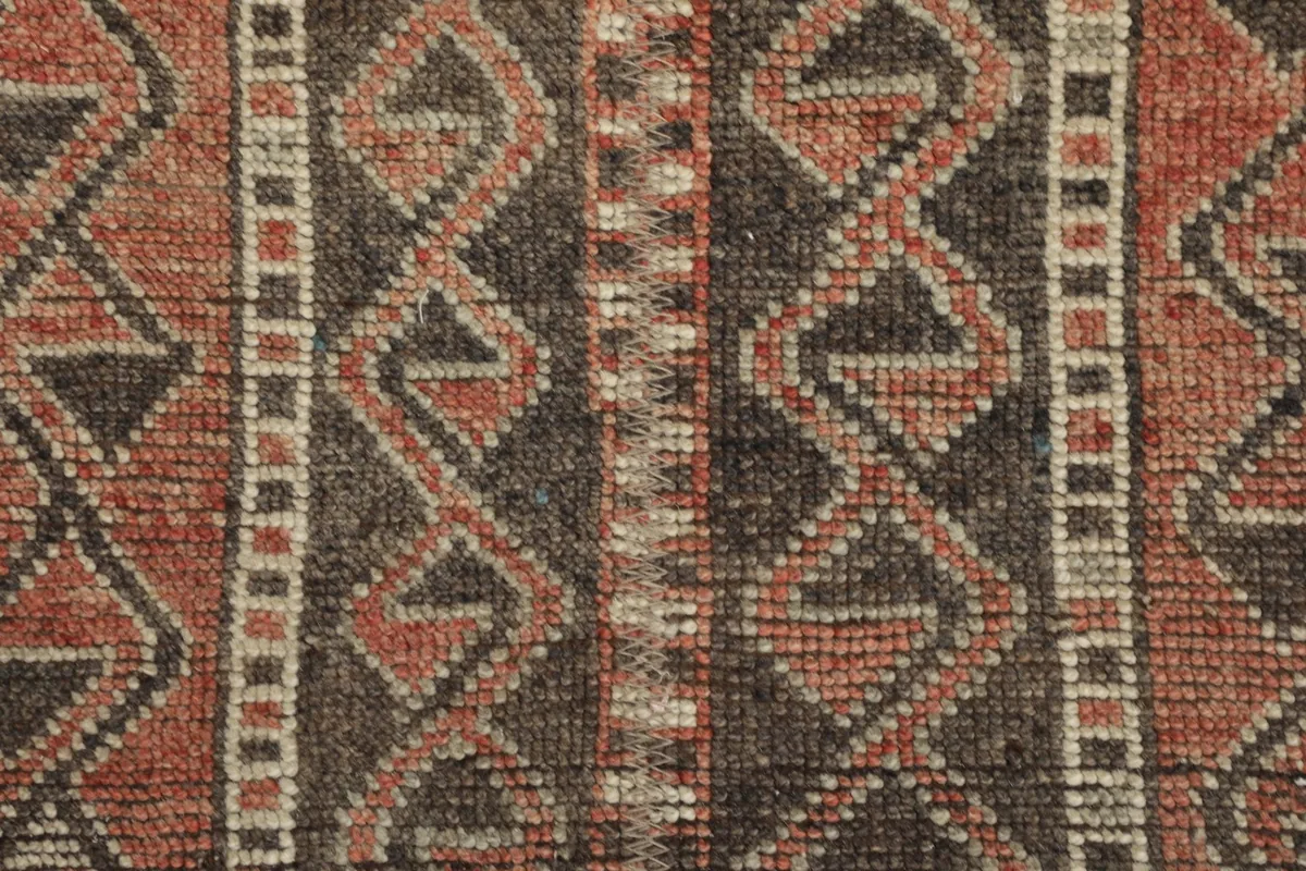 Extreme close-up showing the low wool pile and intricate hand-knotted details of the rug