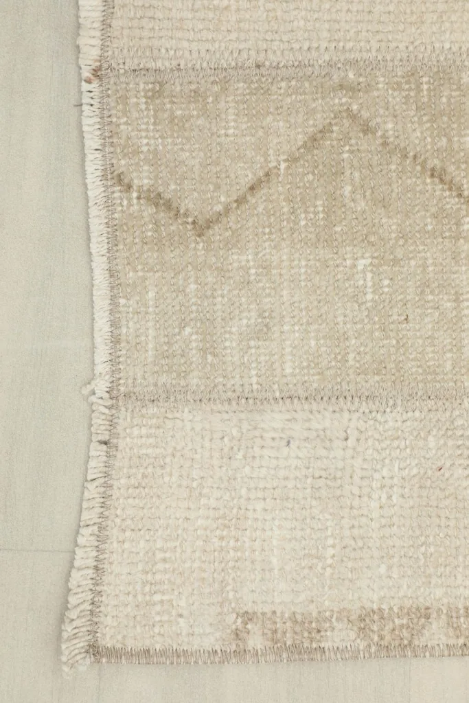 Detail of the runner's short fringe and the edge finishing, showing the cotton foundation.