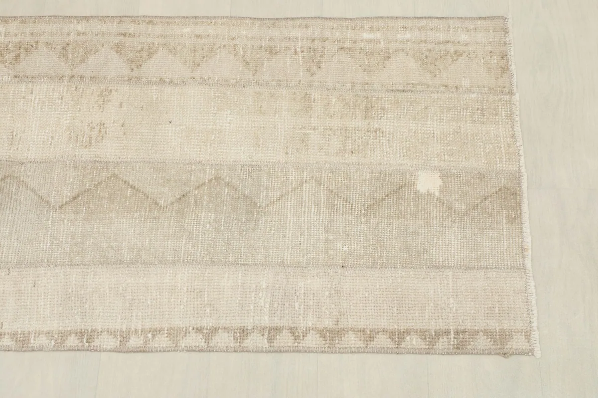 Close overhead view of the tan runner, highlighting the striped geometric patterns and texture.