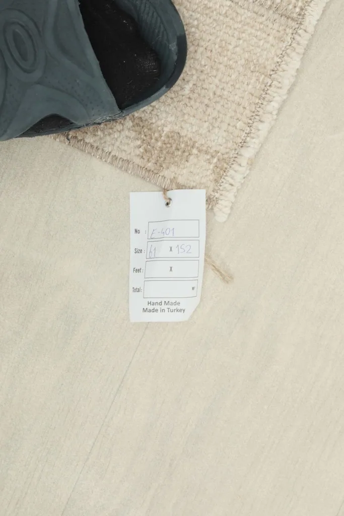 Close-up of the product tag indicating the rug is hand-made in Turkey, next to the rug pile.