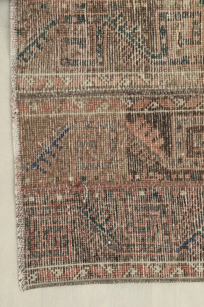 Detailed view of the rug's corner, showcasing the hand-knotted texture and color blend.