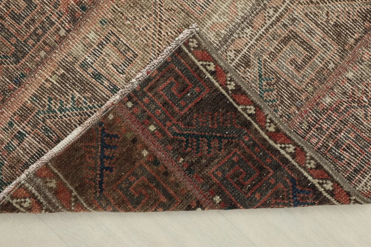 View of the rug's underside, showing the cotton foundation and reverse of the hand-knotted wool pile.