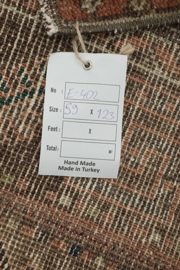 Tag showing the rug's dimensions in centimeters (59 x 123 cm) and its origin as handmade in Turkey.
