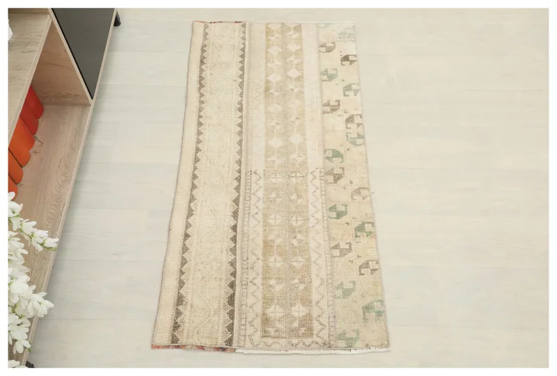 Full top view of the 1'11" x 4'1" beige striped geometric runner rug on a white background.