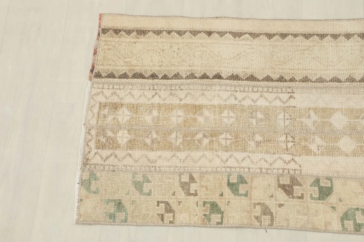 Close view of the rug's patterns, highlighting the texture and color variations from wear.
