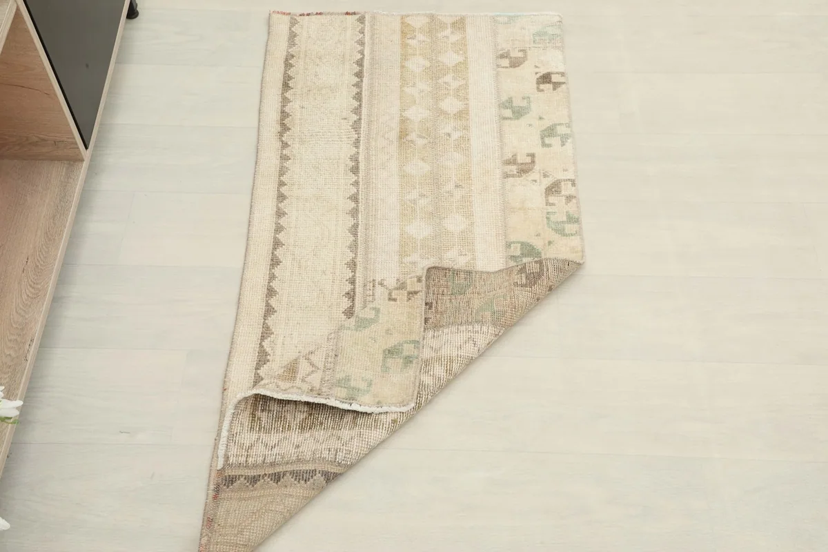 The rug partially folded, showing both the front and the back texture on a light floor.