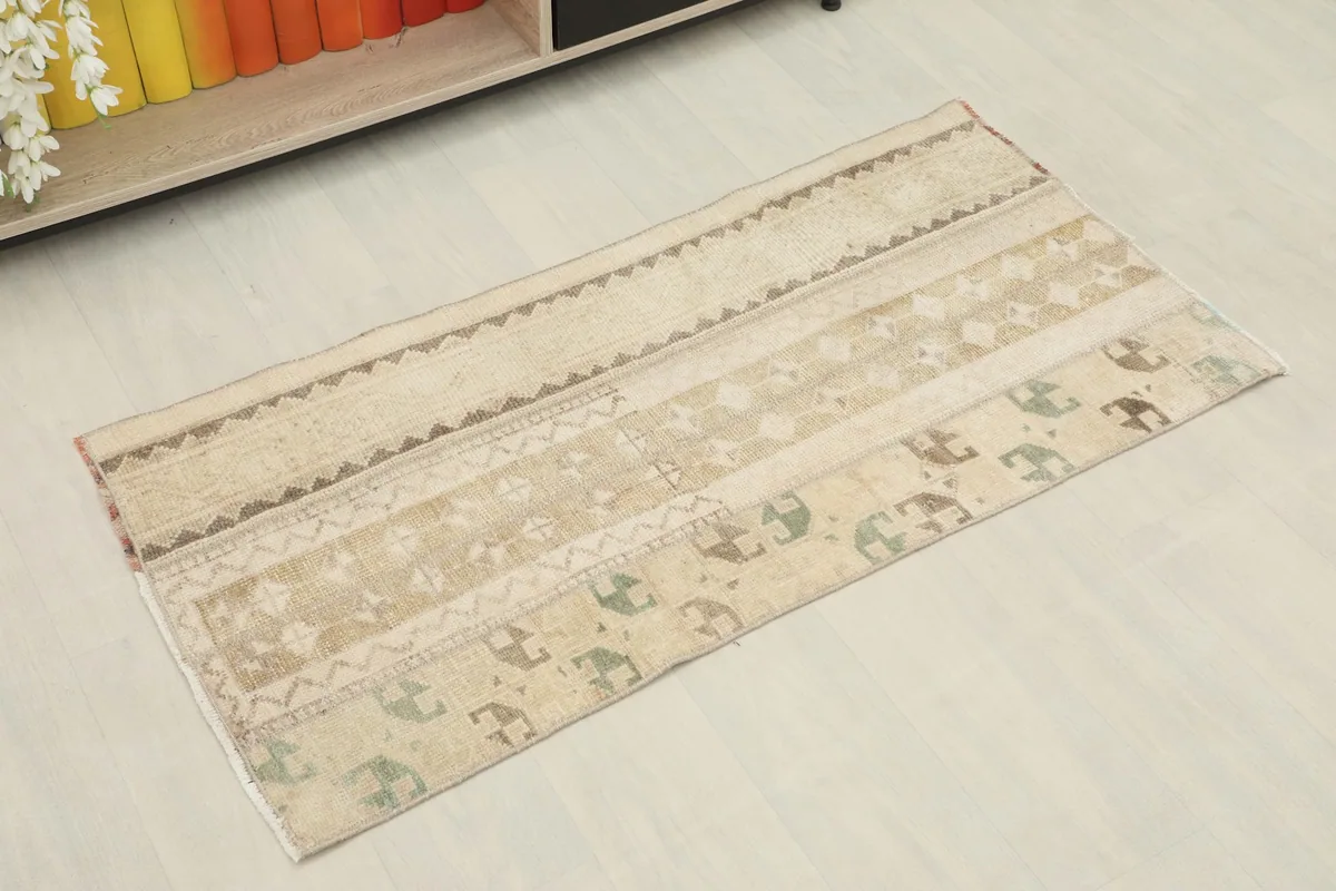 Overhead angled view of the beige, tan, and olive striped Anatolian runner rug.