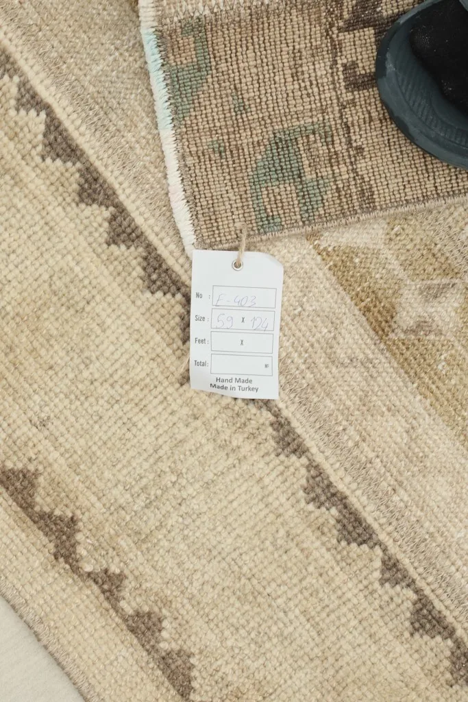 A section of the rug showing the original tag, confirming its hand-knotted origin and material.