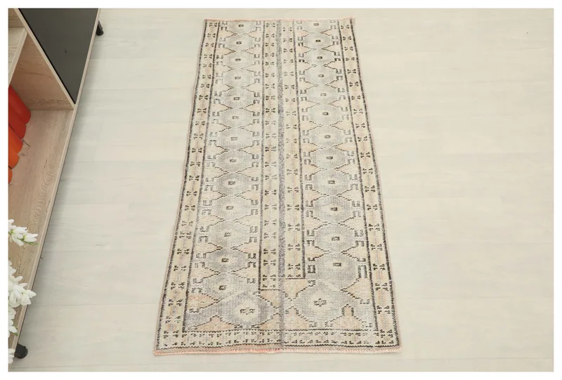 Full overhead view of the beige and gray geometric vintage rug