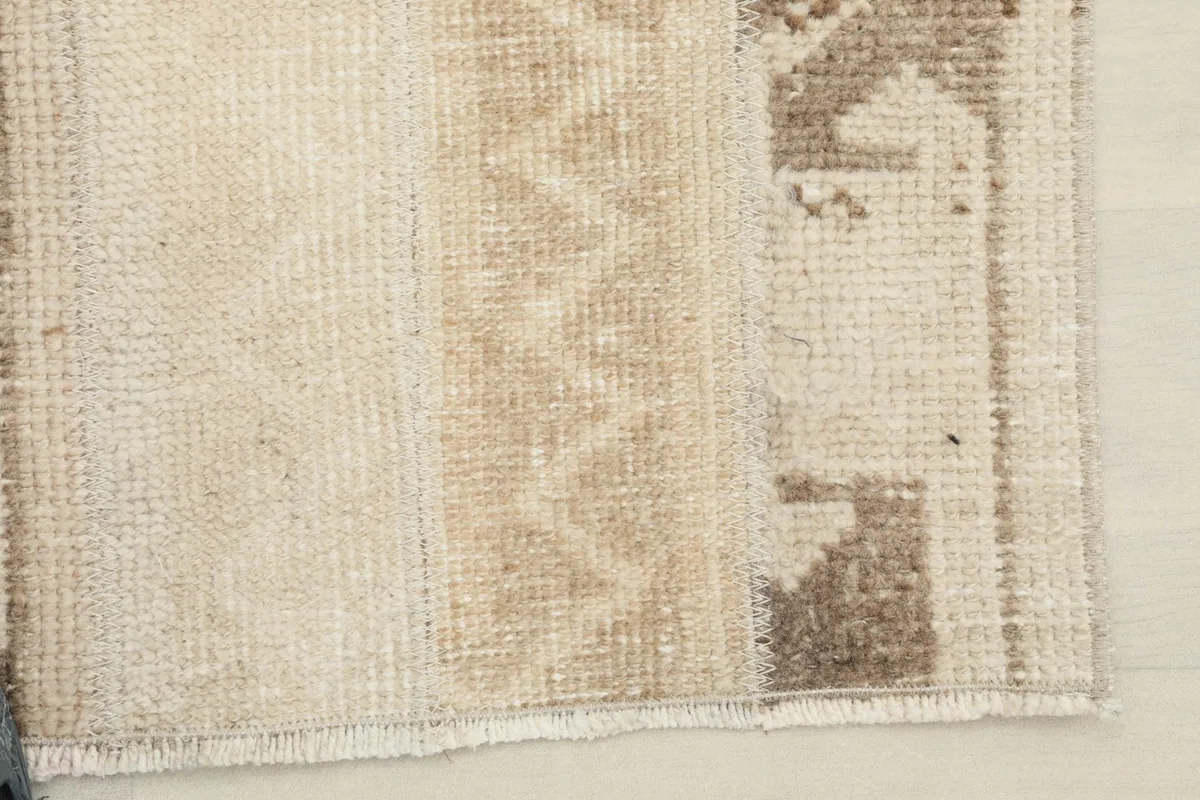 Close-up of the edge and fringe of the beige Anatolian rug, showing professional finish