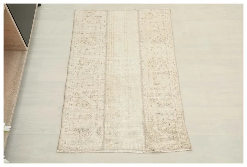 Full top view of the ivory and tan patchwork vintage rug on a white background