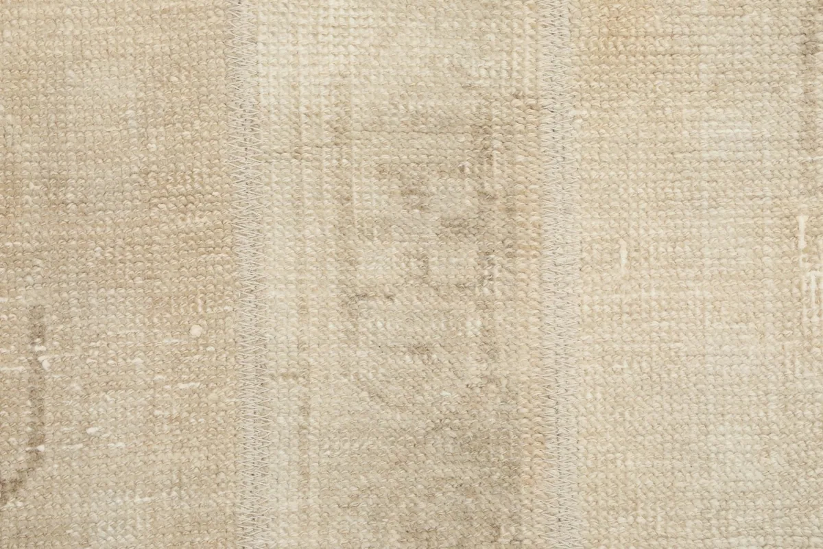 Extreme close-up of the rug's low wool pile, showing the texture and slight variations in color