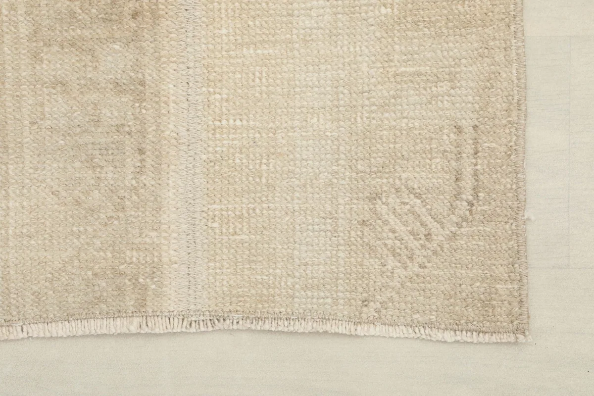 Detail of the rug's edge, showing the minimal fringe and the hand-finished quality