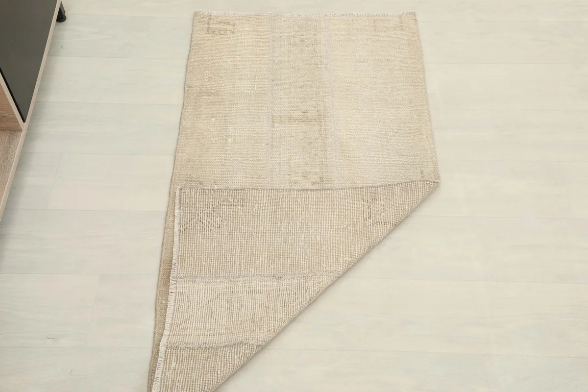 The rug partially folded, demonstrating its flexibility and showing both top and bottom surfaces