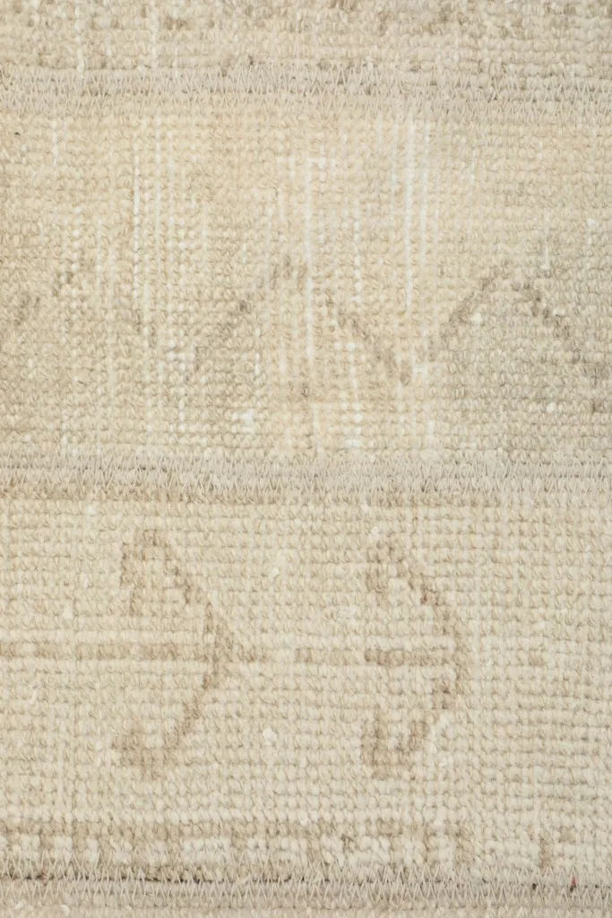Detailed close-up of the hand-knotted texture and beige tribal motifs
