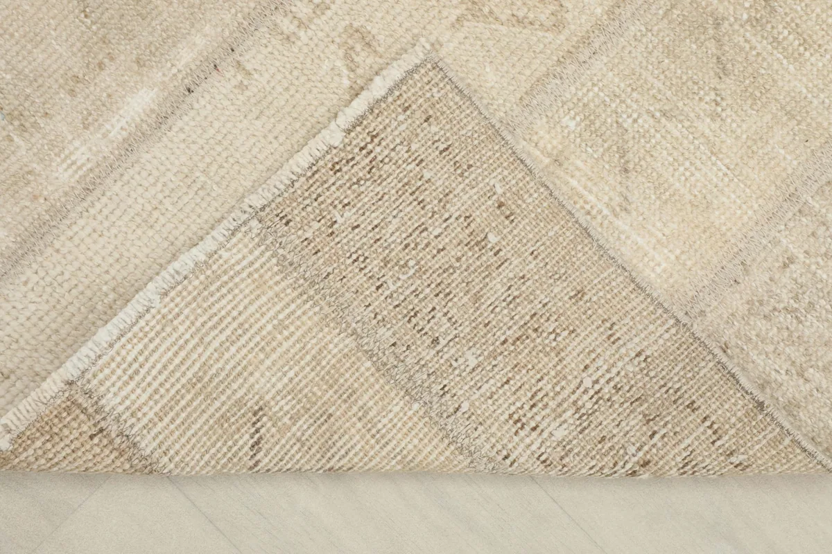 View of the rug's cotton foundation from the back, showing hand-knotted construction