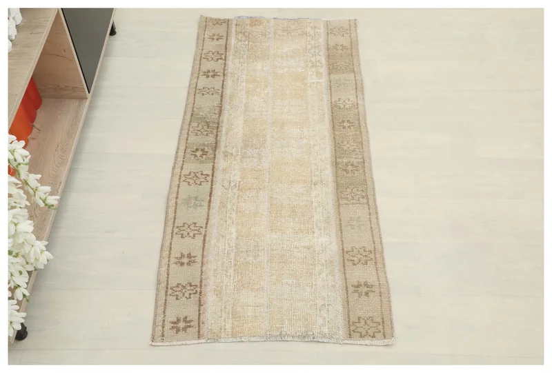 Full top view of the beige and brown vintage Anatolian rug on a white background.