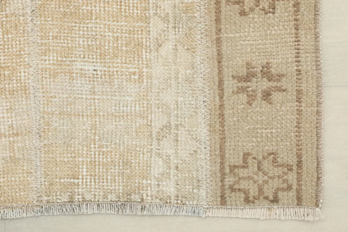Detail of the rug's edge, showing the hand-knotted wool pile and cotton foundation.