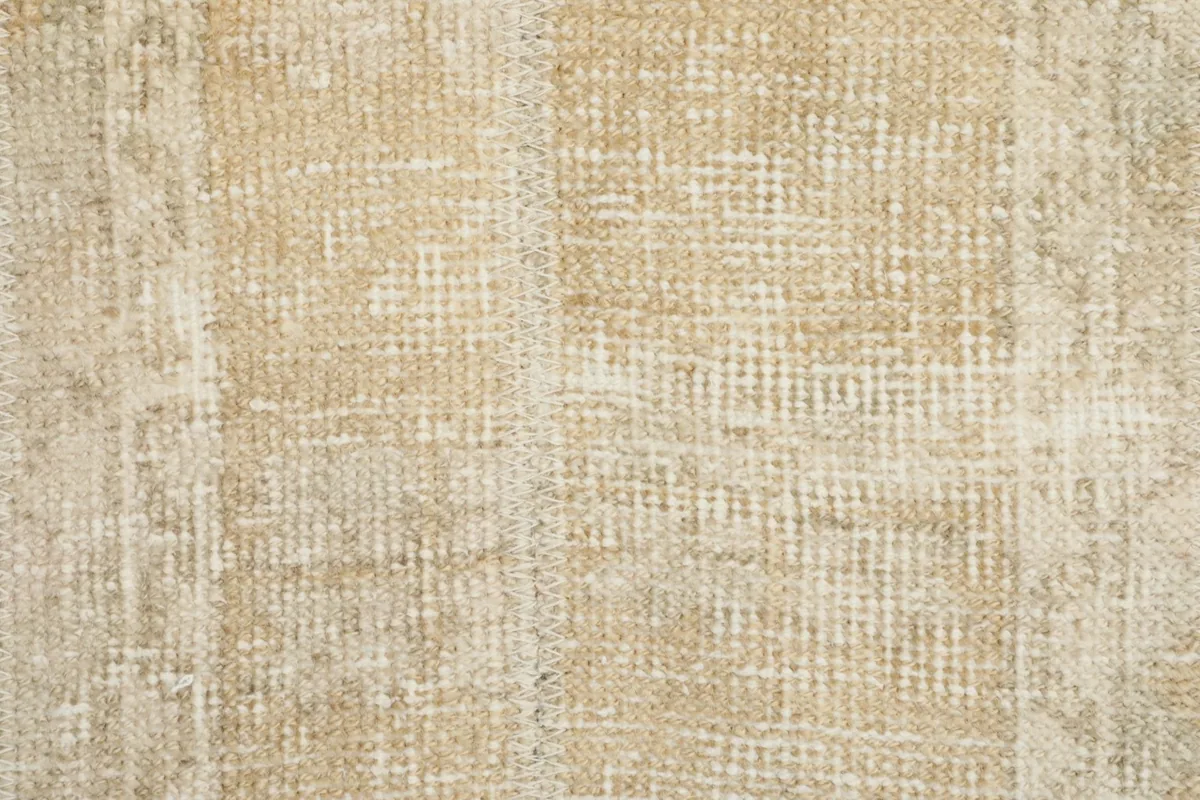 Close-up of the low wool pile, showing the texture and distressed character of the rug surface.