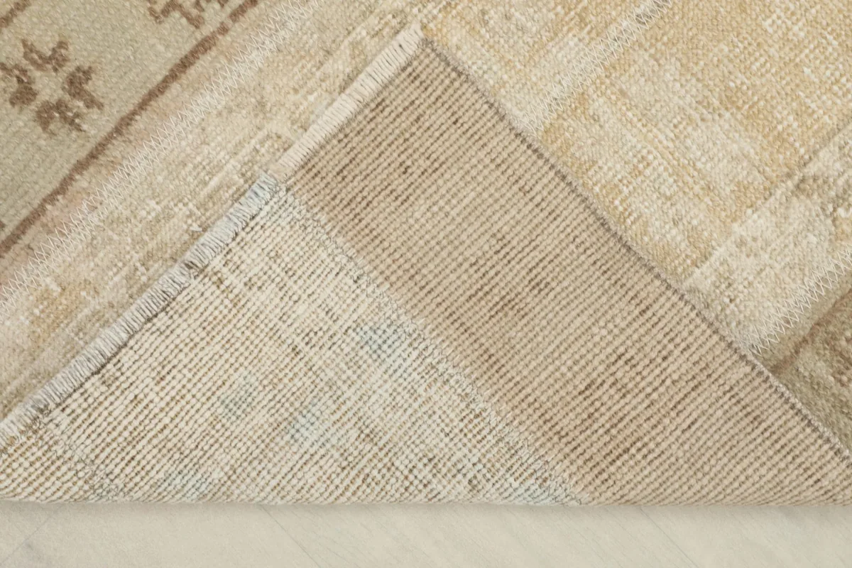 View of the back of the rug, revealing the cotton foundation and knotting structure.